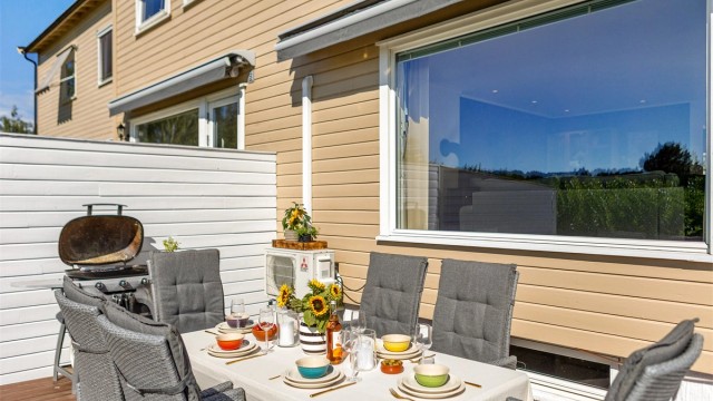 Her ligger alt til rette for lange sommermiddager med familie og venner, mens barna løper fritt rundt på den skjermede uteplassen.
