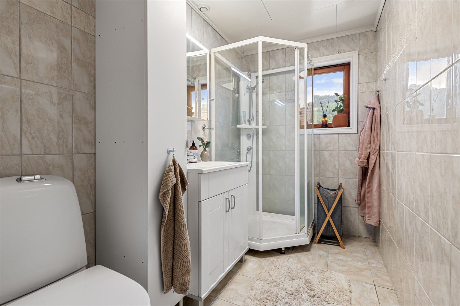 Badet i første etasje har fliser på gulv og vegger, samt gulvvarme.