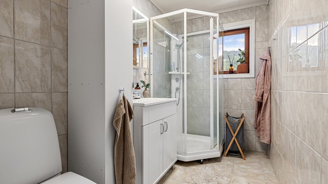 Badet i første etasje har fliser på gulv og vegger, samt gulvvarme.