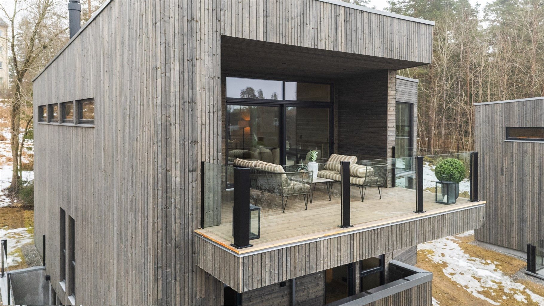 Boligen ligger tilbaketrukket i tredje rekke fra veien, og grenser mot Midtåsen-skogen.