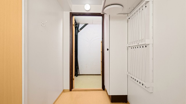 Tørkestativ på vegg og dør inn til bod.