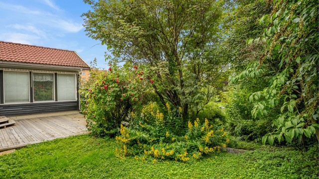 Terrassen ligger fint integrert mot hagen og har direkte adkomst fra boligens stue. Et naturlig samlingspunkt på fine sommerdager, med gode solforhold gjennom store deler av dagen.