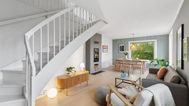 Halvpart av horisontaldelt tomannsbolig over to plan med innredet loftsetasje og ildsted i stuen.
Foto: EFKT