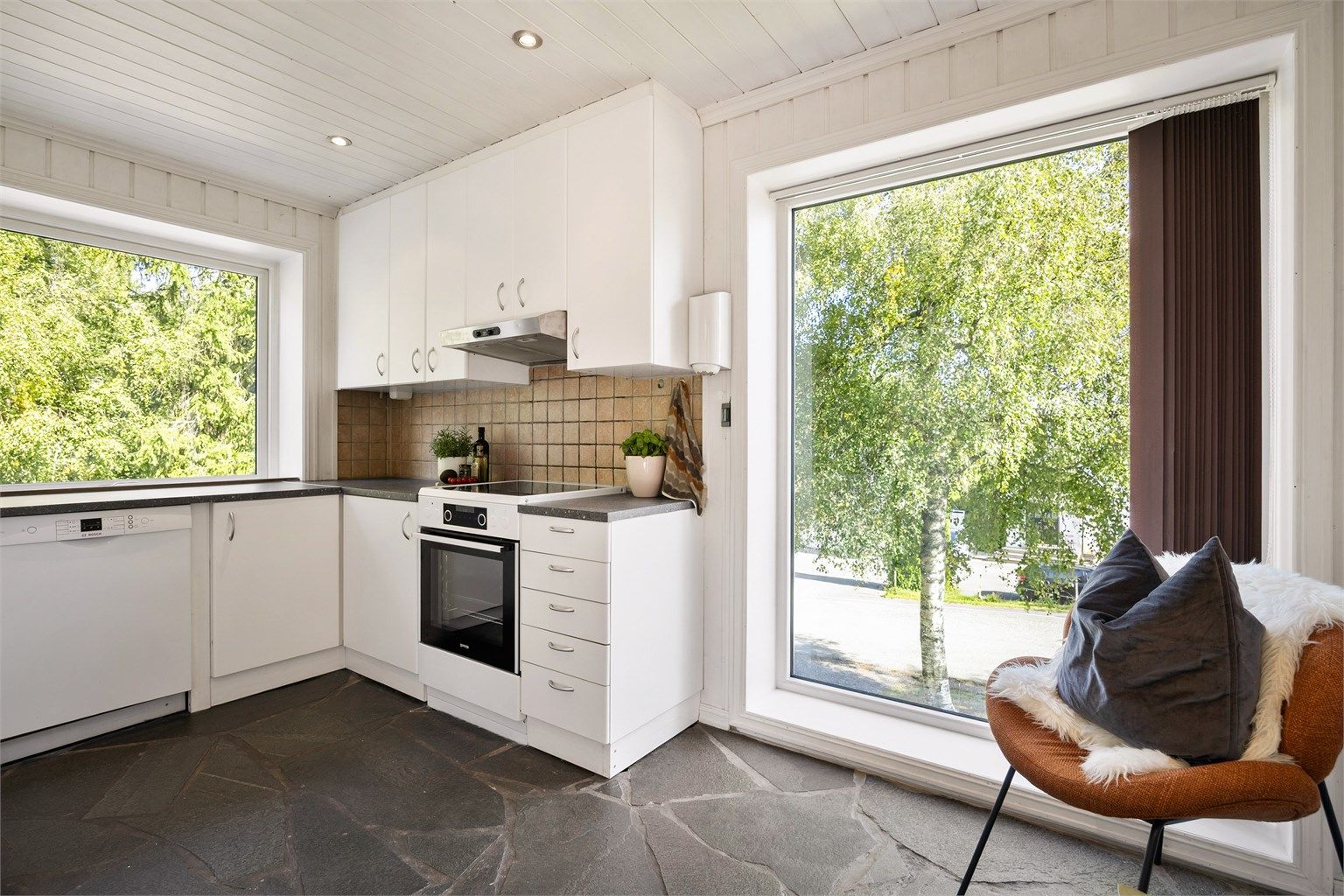 Kjøkkeninnredning fra 2007 med over- og underskap i hvit samt glatt utførelse.