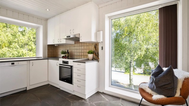 Kjøkkeninnredning fra 2007 med over- og underskap i hvit samt glatt utførelse.