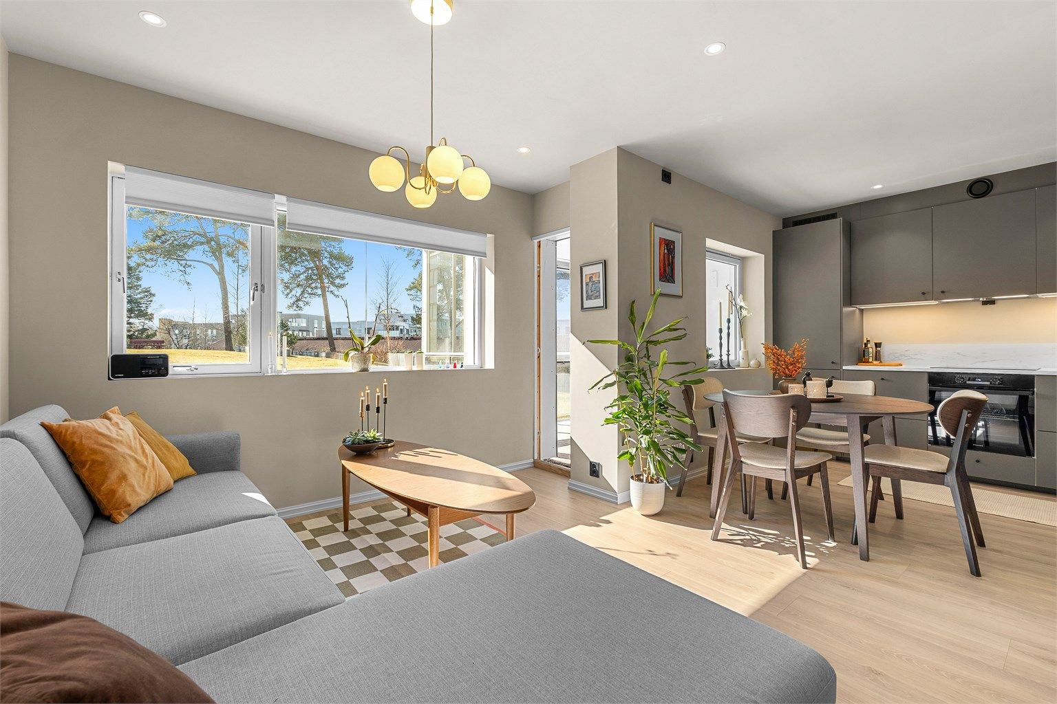 Den åpne planløsningen mellom stue og kjøkken skaper en romslig og sosial helhet.