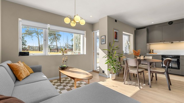 Den åpne planløsningen mellom stue og kjøkken skaper en romslig og sosial helhet.