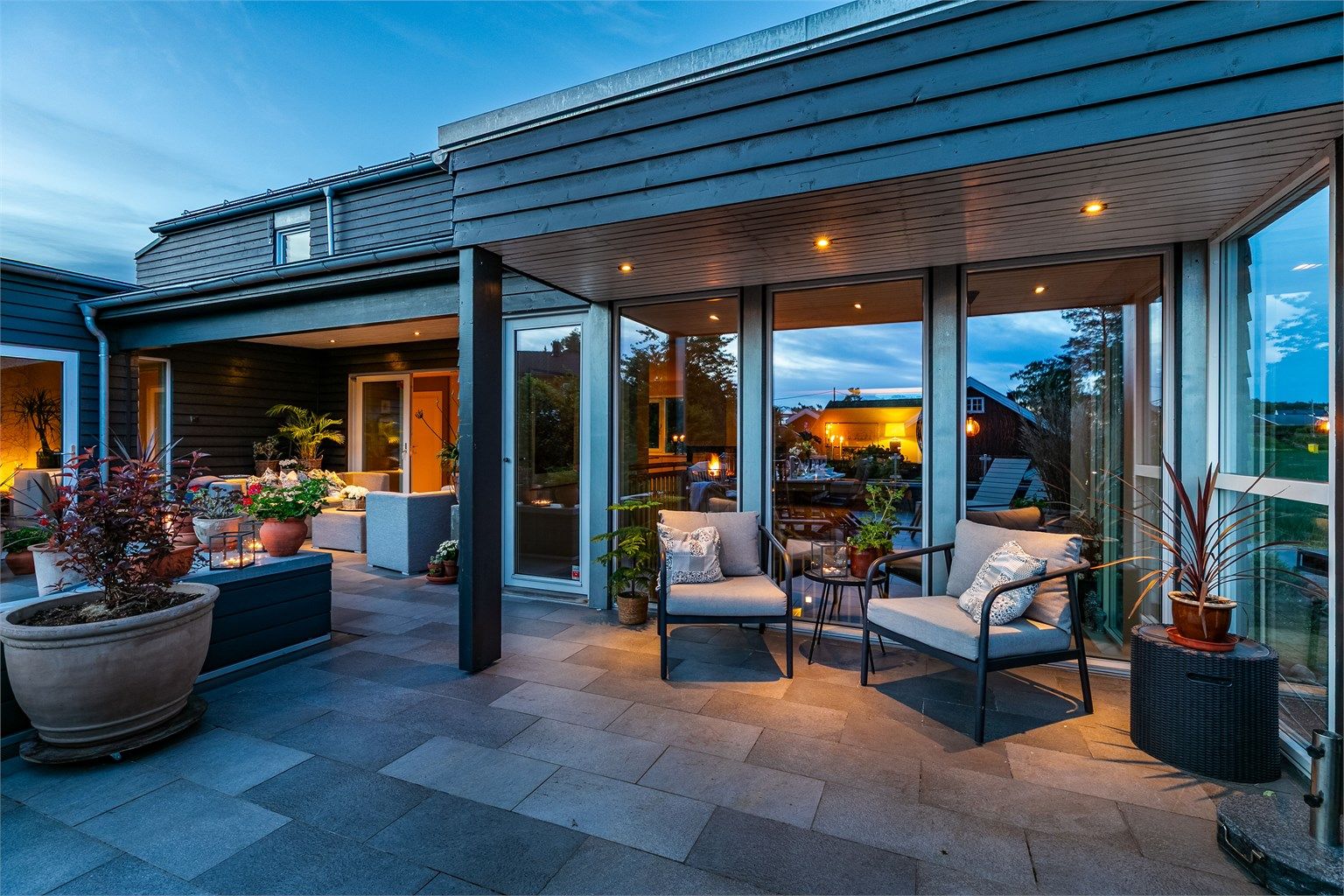 Skjermende overbygg og glass skaper soner, luner og utvider terrassens bruksmuligheter.
