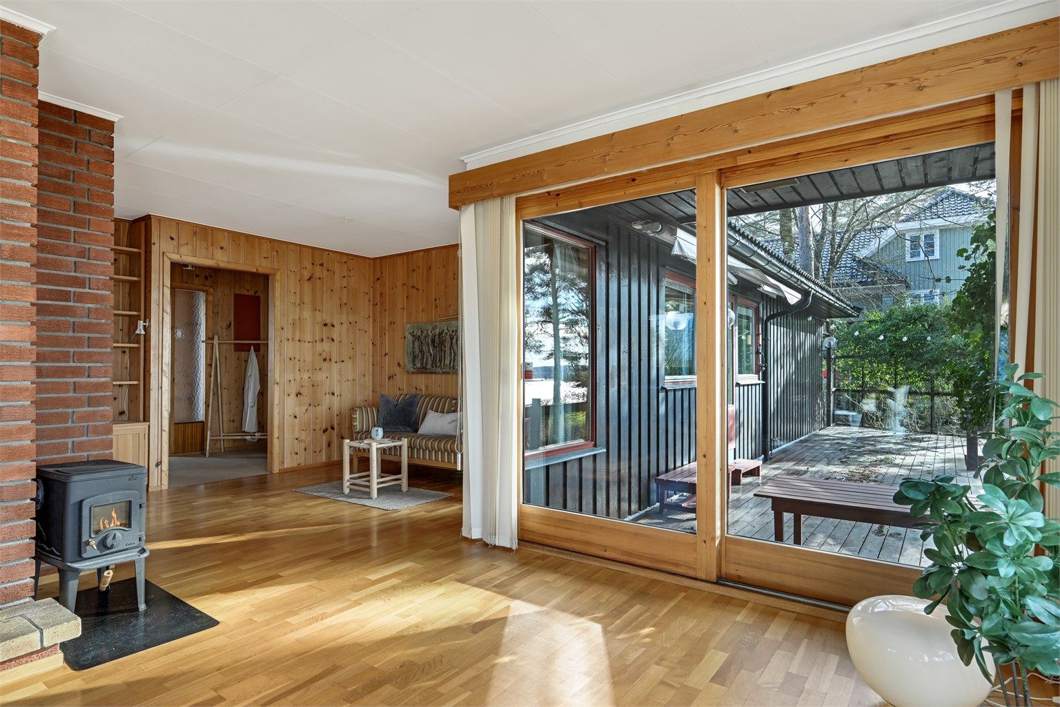 Skyvedører som åpner opp mot en hyggelig terrasse. De store vindusflatene slipper inn rikelig med dagslys og skaper en fin overgang mellom inne- og uteareal.