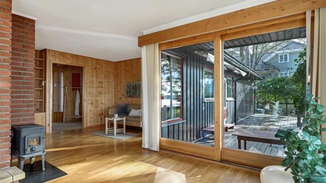 Skyvedører som åpner opp mot en hyggelig terrasse. De store vindusflatene slipper inn rikelig med dagslys og skaper en fin overgang mellom inne- og uteareal.