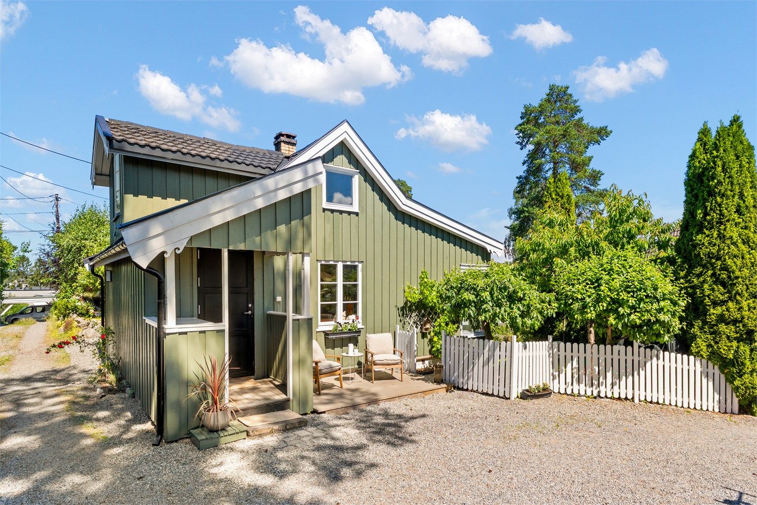 Husets klassiske uttrykk, kombinert med det hvite stakittgjerdet ved inngangspartiet, gir eiendommen en sjelden sjarmerende karakter. 
Foto: Løvås Foto