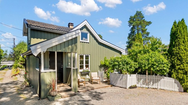 Husets klassiske uttrykk, kombinert med det hvite stakittgjerdet ved inngangspartiet, gir eiendommen en sjelden sjarmerende karakter.
Foto: Løvås Foto