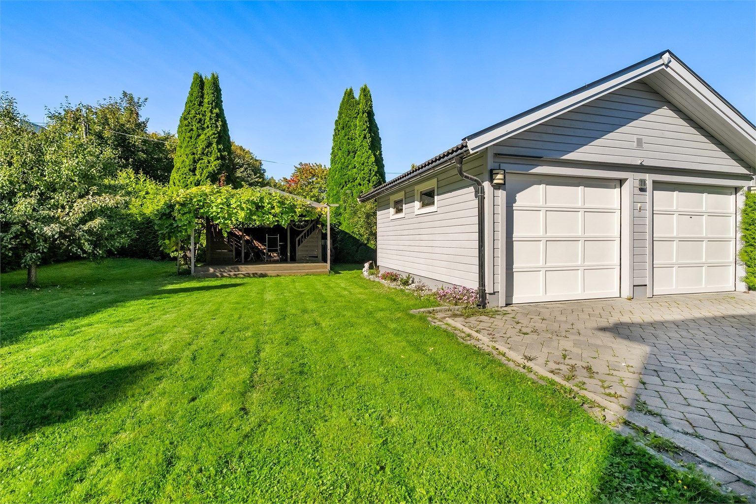 Solrik tomt med hage, garasje og steinlagt gårdsplass