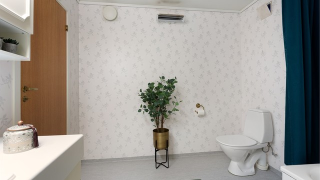 Badet har gulvbelegg, tapetserte vegger og malt himling.