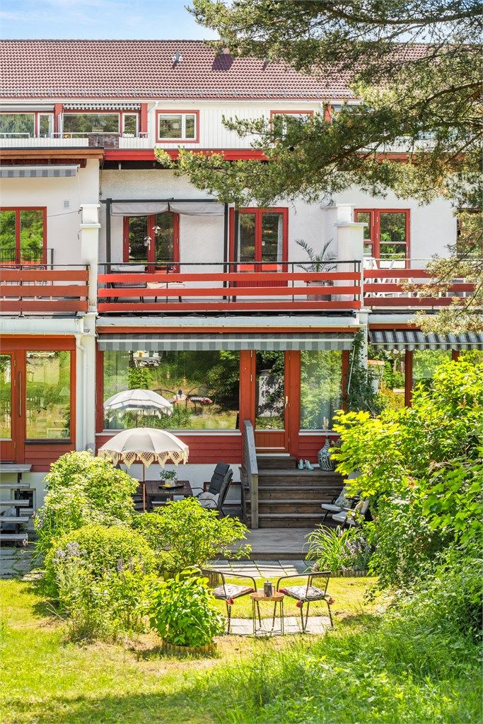 Fasaden mot hagen strekker seg over tre plan, med utgang til både terrasse og altan.