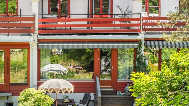 Fasaden mot hagen strekker seg over tre plan, med utgang til både terrasse og altan.