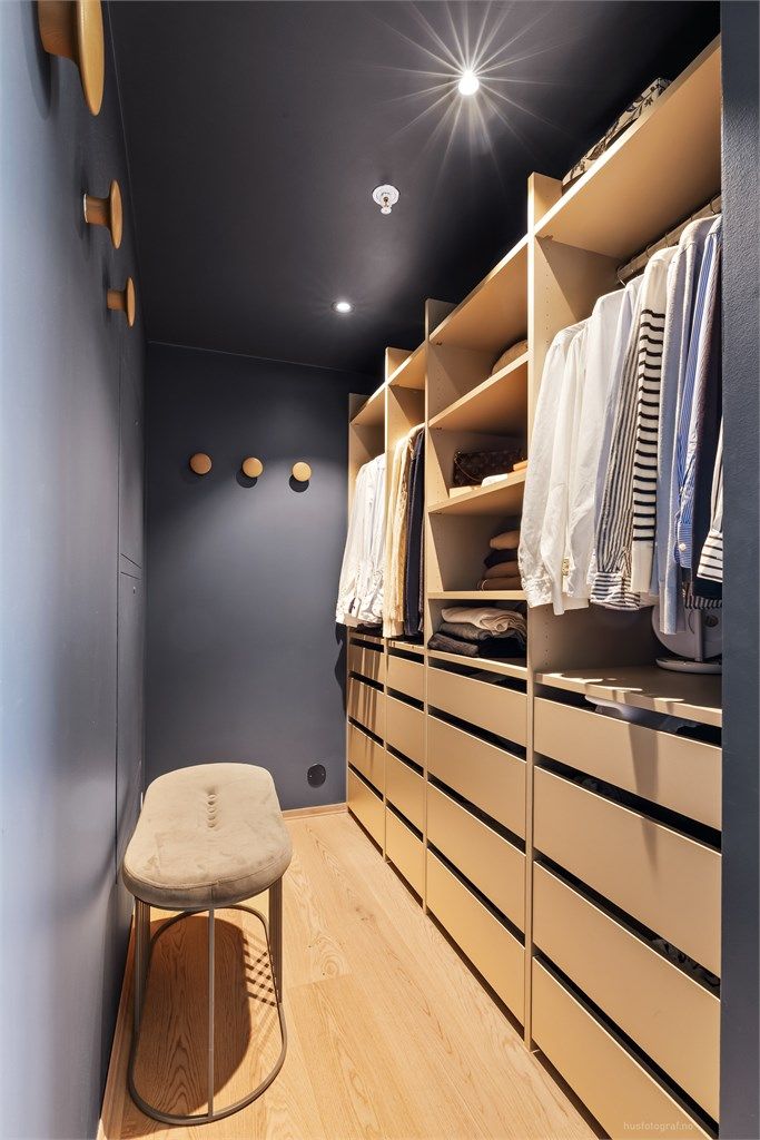 Walk-in garderobe med åpen garderobeløsning som har hyller, klesskinner og skuffer.