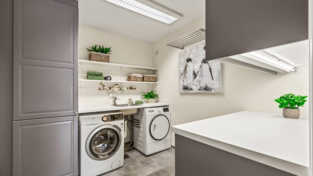 Eget vaskerom med flislagt gulv, skapinnredning, utslagsvask og god plass til både vaskemaskin samt tørketrommel. Rommet er ikke bruksendret/omsøkt.
