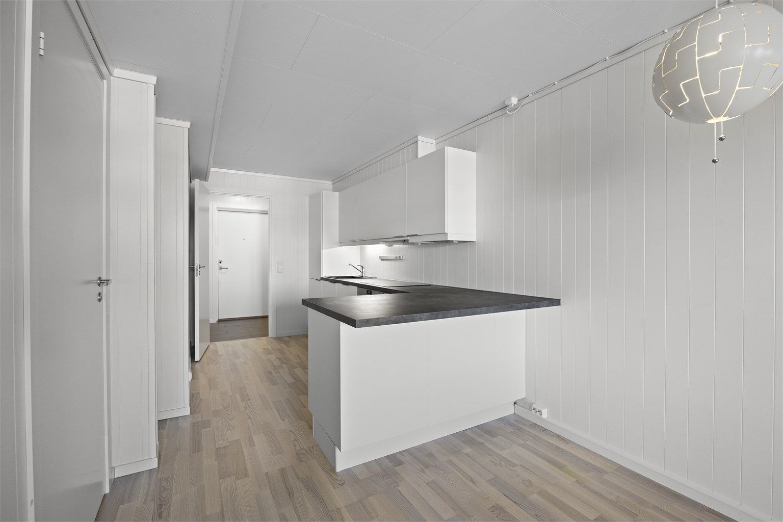 Kjøkkenhalvøya gir ekstra benkeplass og et naturlig skille mot stuen.