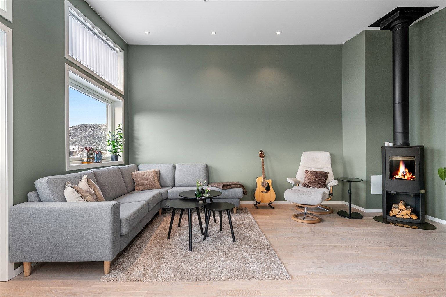 Den gode takhøyden i stuen gir en luftig romfølelse, og vedovnen skaper en lun atmosfære.