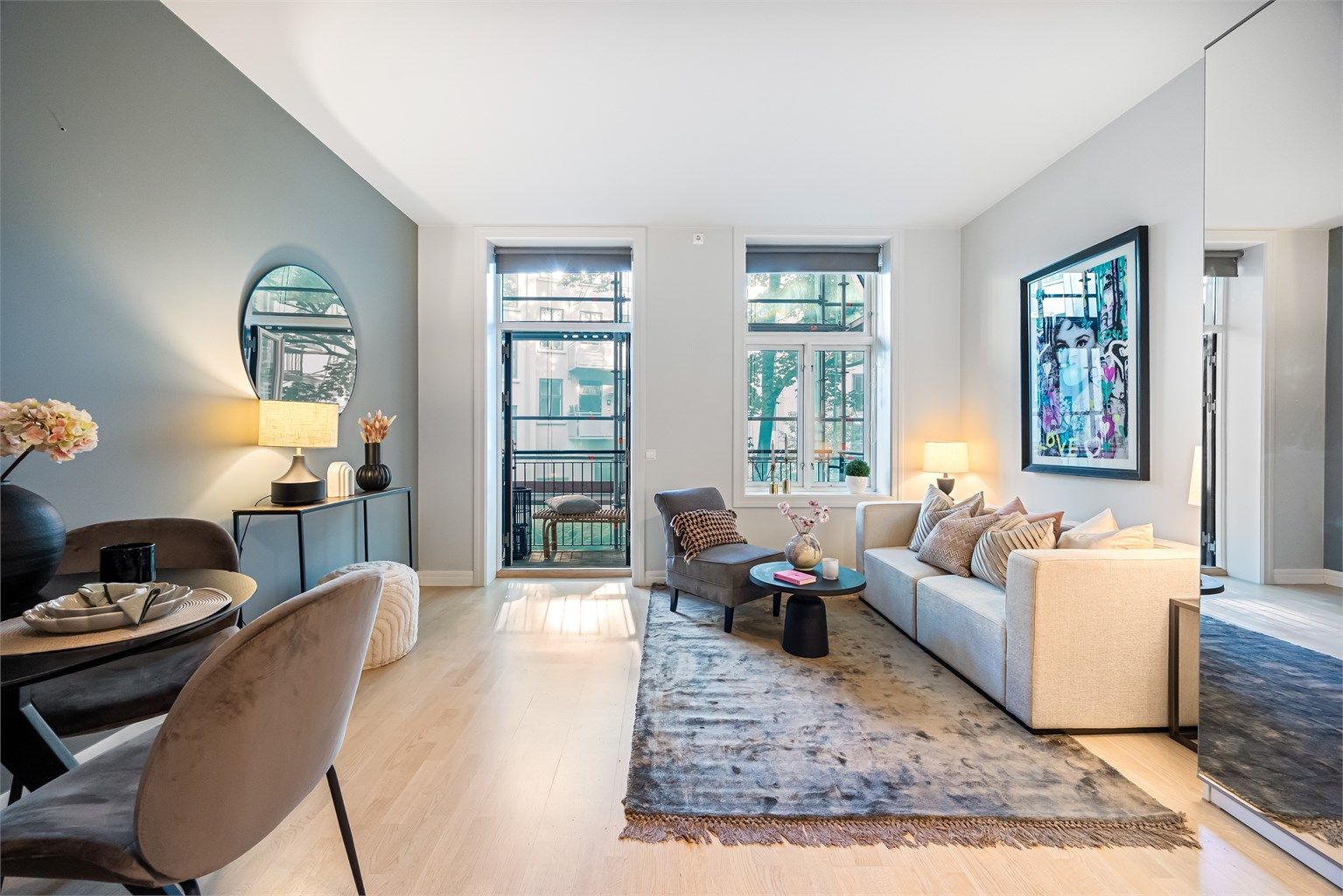 Lys og trivelig stue med store vindusflatene og utgang til balkong som gjør at rommet blir opplevd som lyst og luftig.