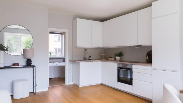 Materialvalg som heltre benkeplate og glatte fronter skaper et kjøkken med et tidløst og innbydende preg.