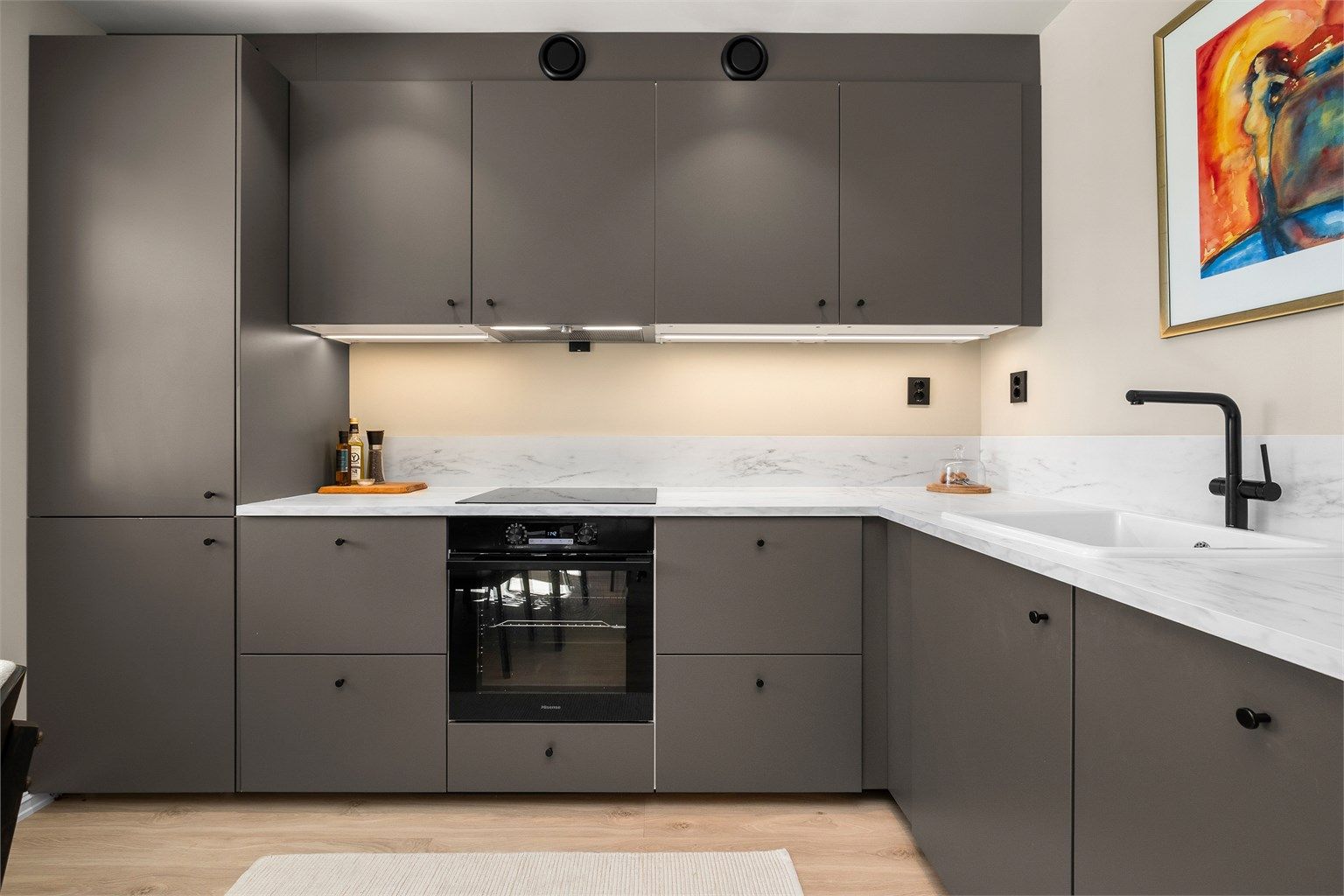 Kjøkkenet har et moderne uttrykk med slette fronter, gode arbeidsflater og en tidløs fargepalett.