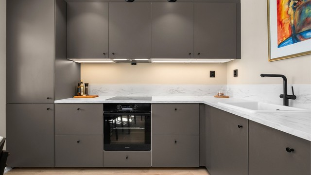 Kjøkkenet har et moderne uttrykk med slette fronter, gode arbeidsflater og en tidløs fargepalett.