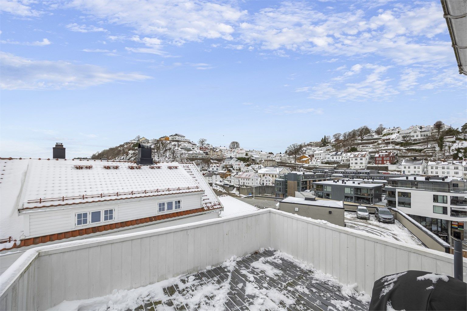 Utsikten fra verandaen strekker seg over hustakene i nærområdet.