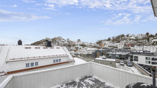 Utsikten fra verandaen strekker seg over hustakene i nærområdet.