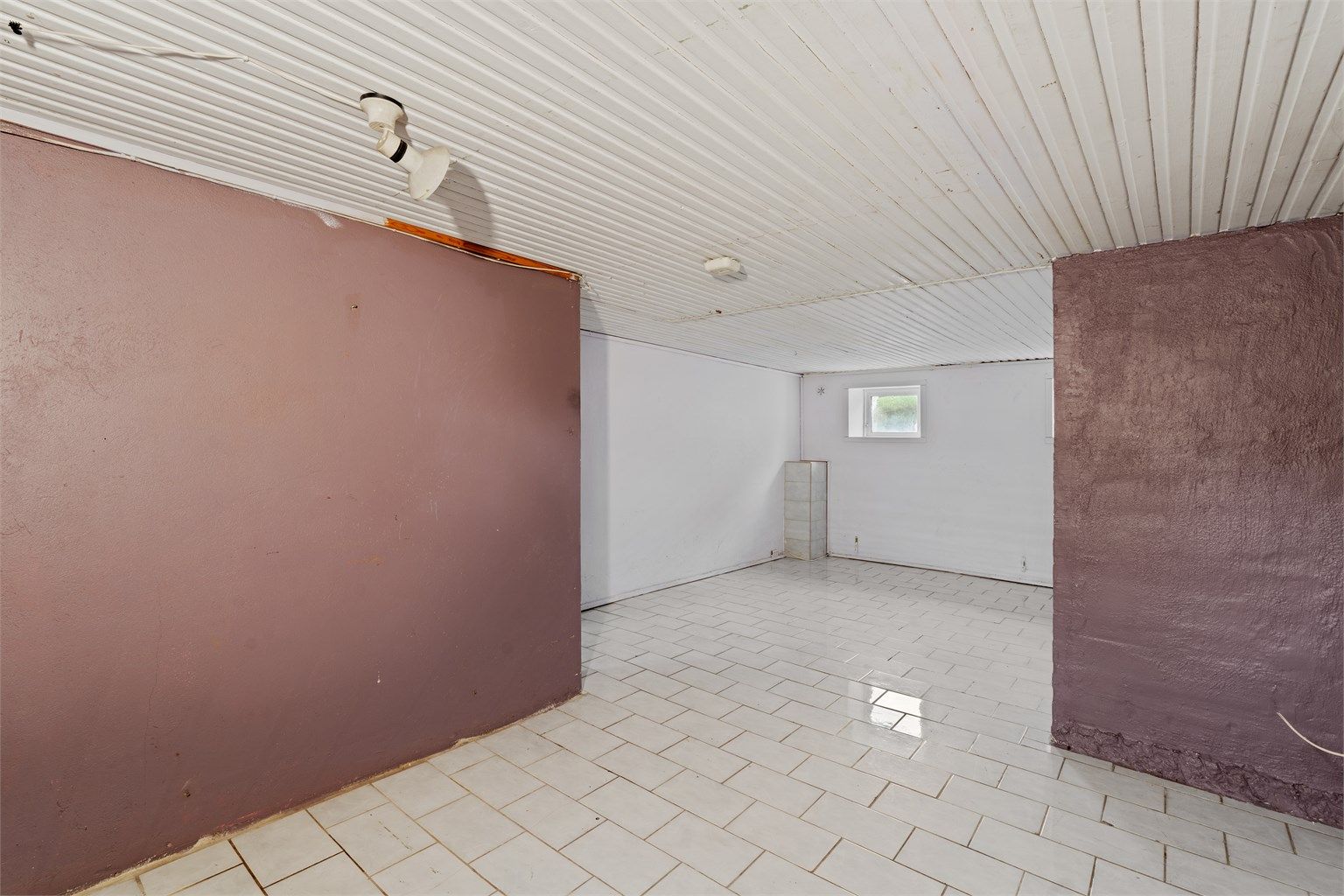 Flislagte flater og panelbord i himling i kjelleretasjen.