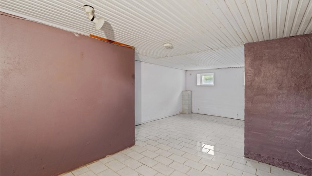 Flislagte flater og panelbord i himling i kjelleretasjen.