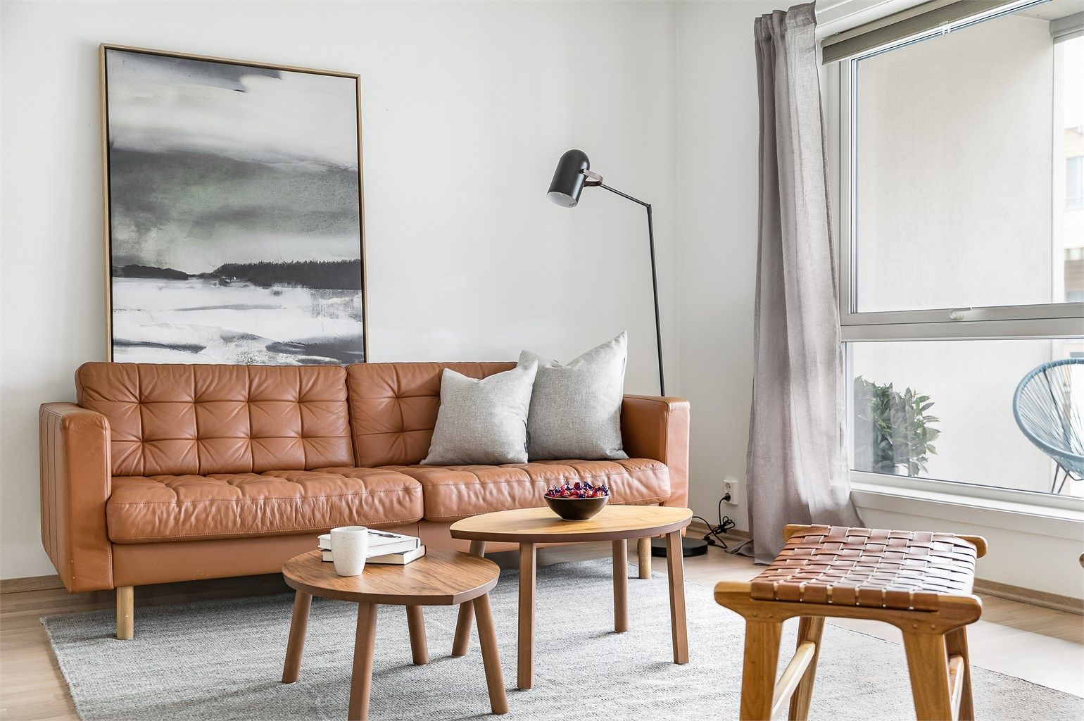 Store vinduer og høyden av tredje etasje fremmer gode lysforhold i stuen dagen gjennom.