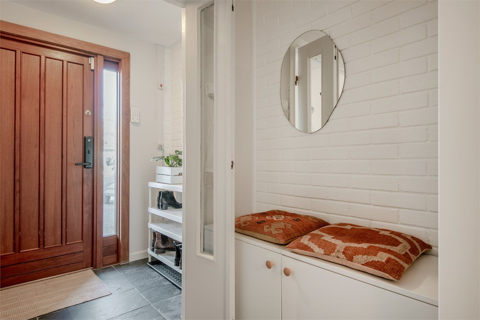 Innbydende entré med flislagt gulv, gulvvarme og detaljer i teglstein.