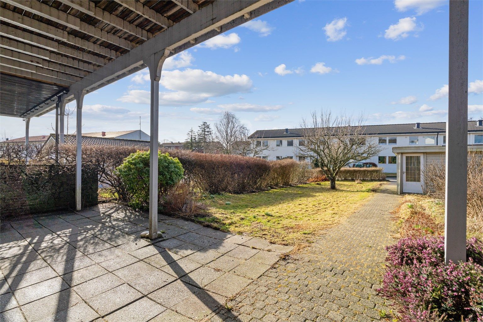 Den skjermede hagen har en hellelagt uteplass og gressplen.