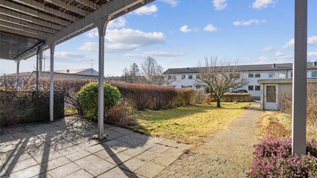 Den skjermede hagen har en hellelagt uteplass og gressplen.