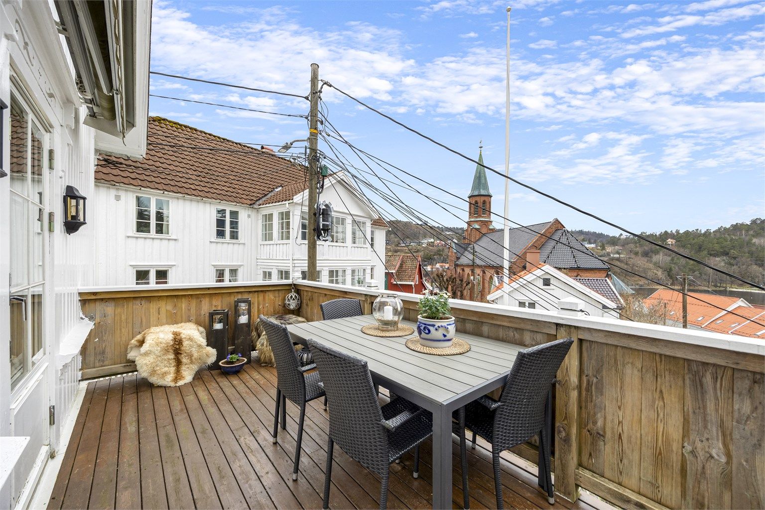 Flott veranda fra 2003 med kveldssol og utsikt. Det er montert markise på husveggen.