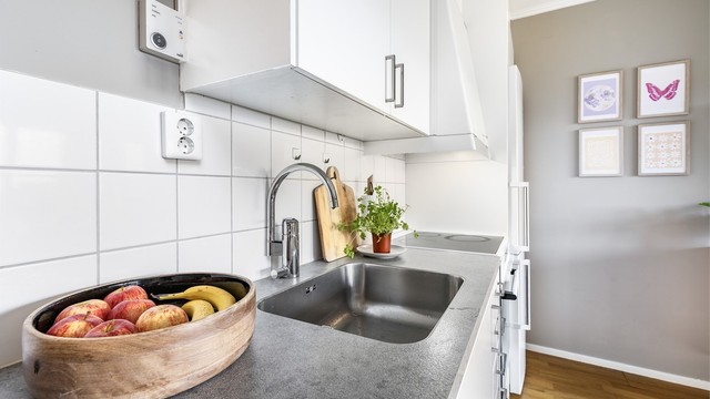 Kjøkkenet er som resten i leiligheten fra byggeåret Svelling i dekkside mot nisje for kjøleskap bør utbedres.
