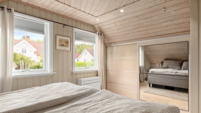 Integrert skyvedørsgarderobe med speilfront og innfelte downlights i himlingen.