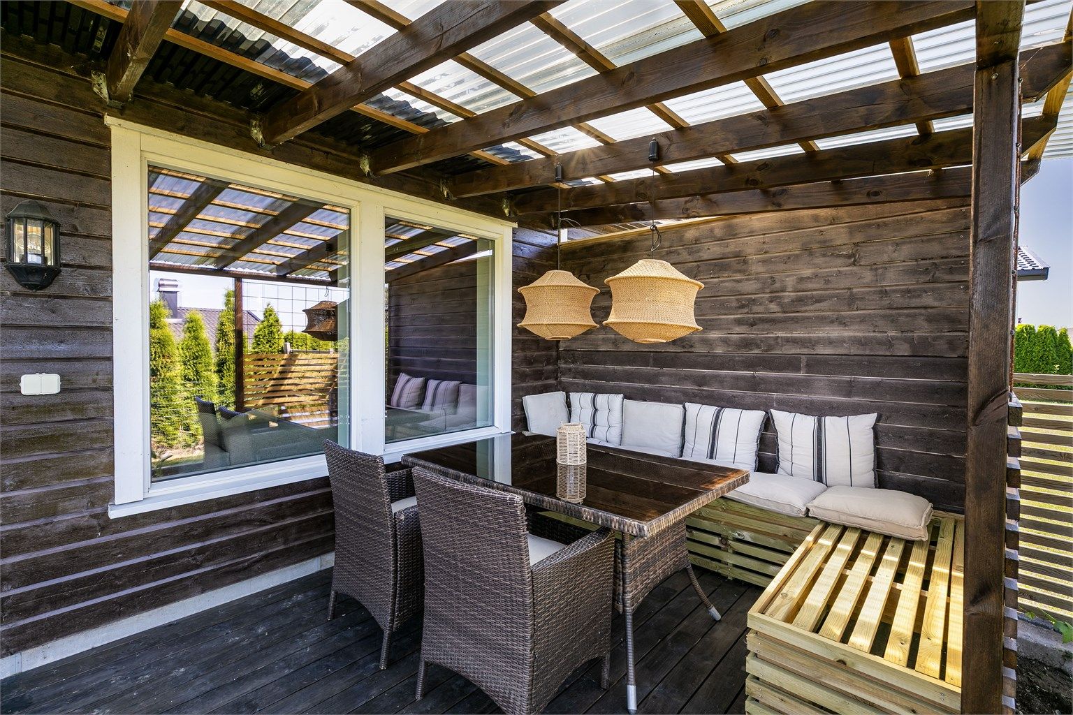 Pergola med tett tak gjør det mulig å sitte ute selv om sommerværet ikke er på sitt aller beste.