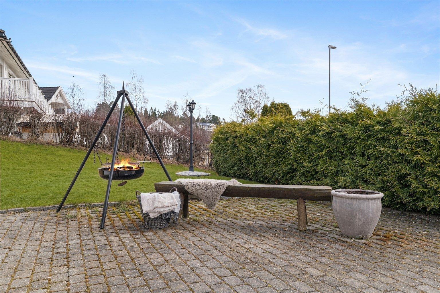 Uteområdet er pent opparbeidet med en romslig gårdsplass belagt med belegningsstein, fine plenarealer og hekker rundt eiendommen.