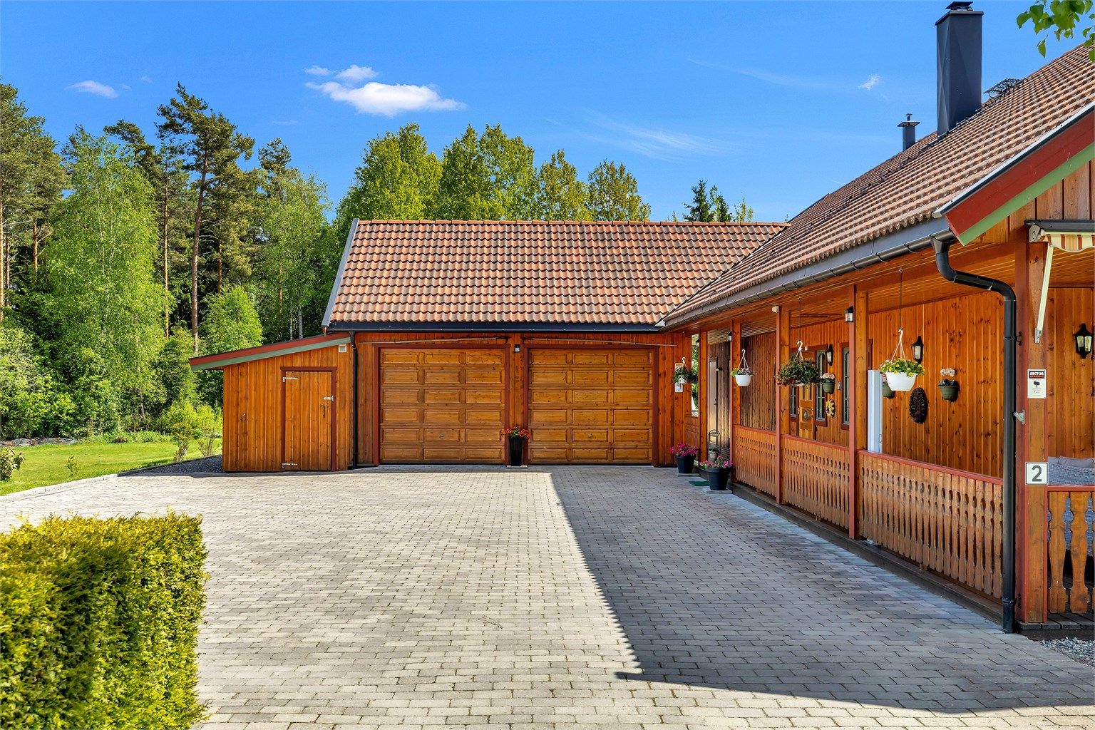Dobbel garasje og pent anlagt innkjørsel i brostein som gir et solid og stilrent førsteinntrykk, og har god plass til flere biler.