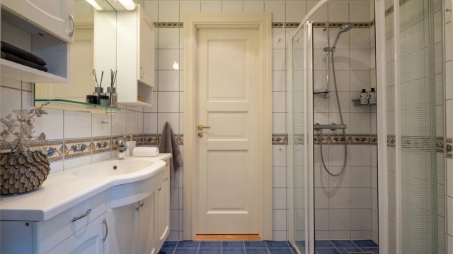 Det er egen dusjsone med skyvedører i glass og vegghengt toalett.