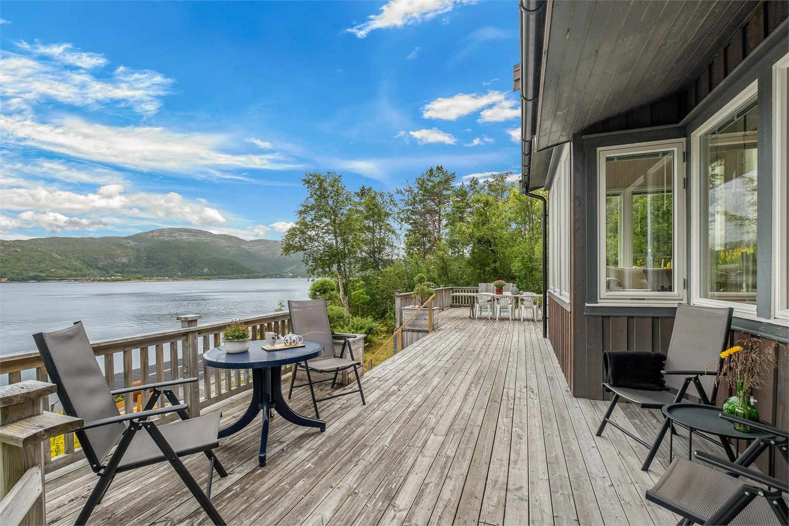 Den romslige terrassen gir god plass til flere sittegrupper og har flott utsyn mot sjøen.