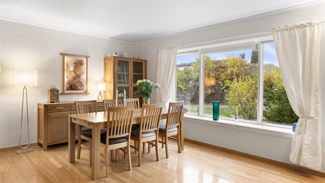 Spiseplassen har fint utsyn mot hagen og åpen forbindelse mot stuearealene.