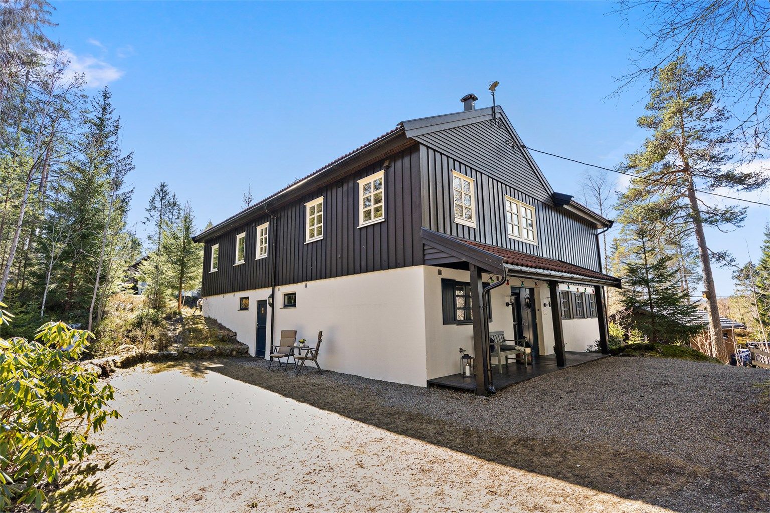 Boligen har en ekstra inngang på baksiden inn til store bodrom med god takhøyde. 