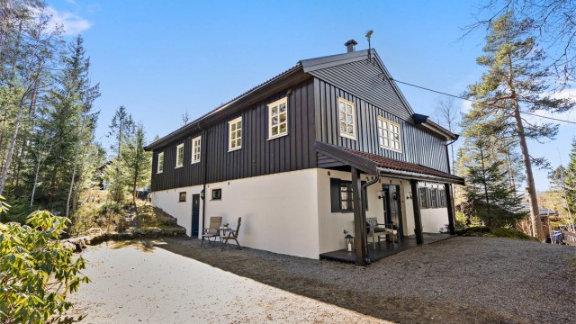 Boligen har en ekstra inngang på baksiden inn til store bodrom med god takhøyde.