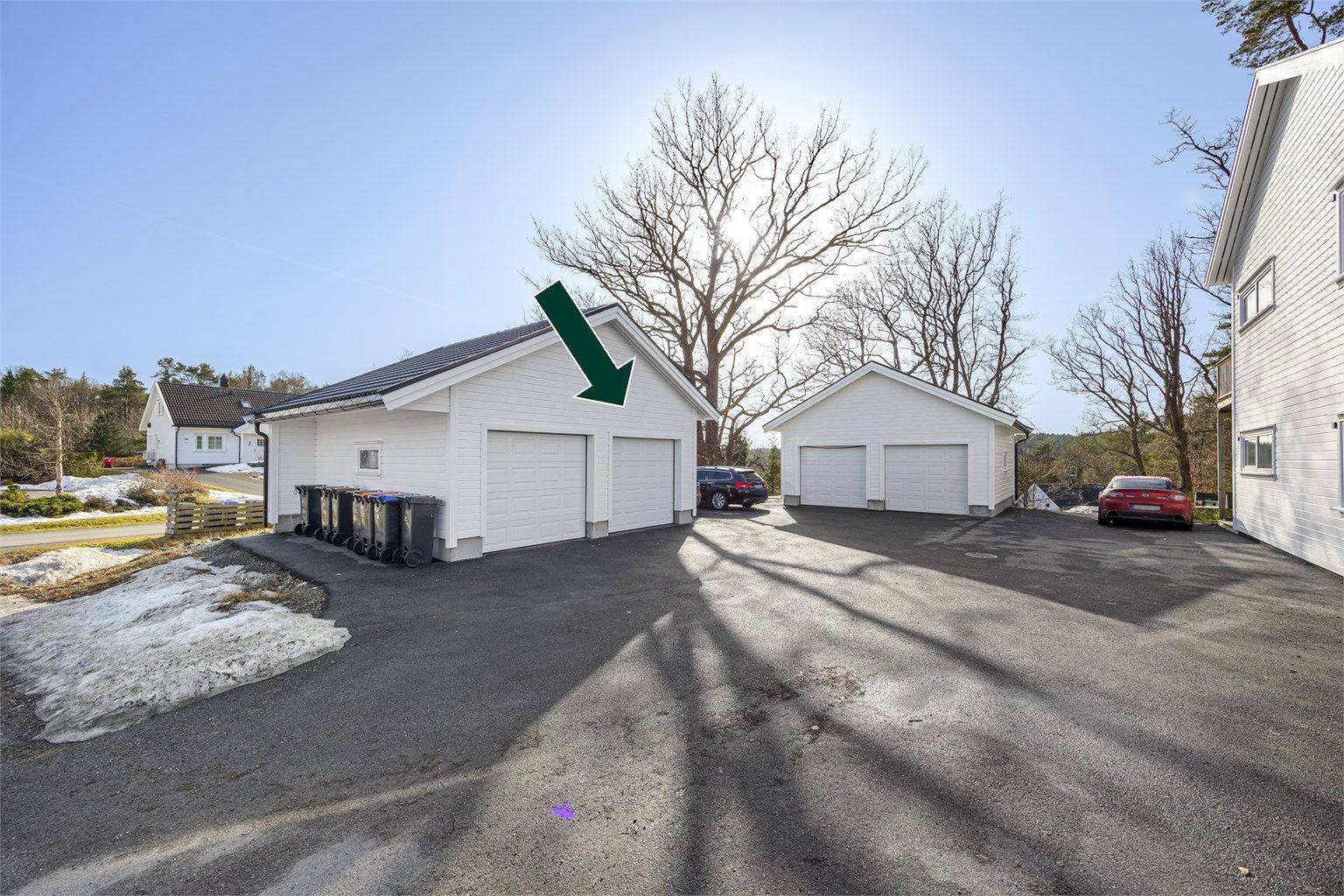 Pilen peker på garasjeplassen/porten som tilhører leiligheten. Dette er tinglyst i seksjoneringen. 