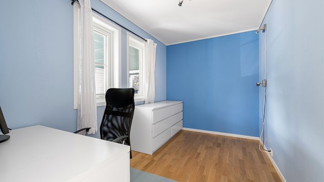 Soverom i underetasjen innredet med kontorpult og oppbevaring.