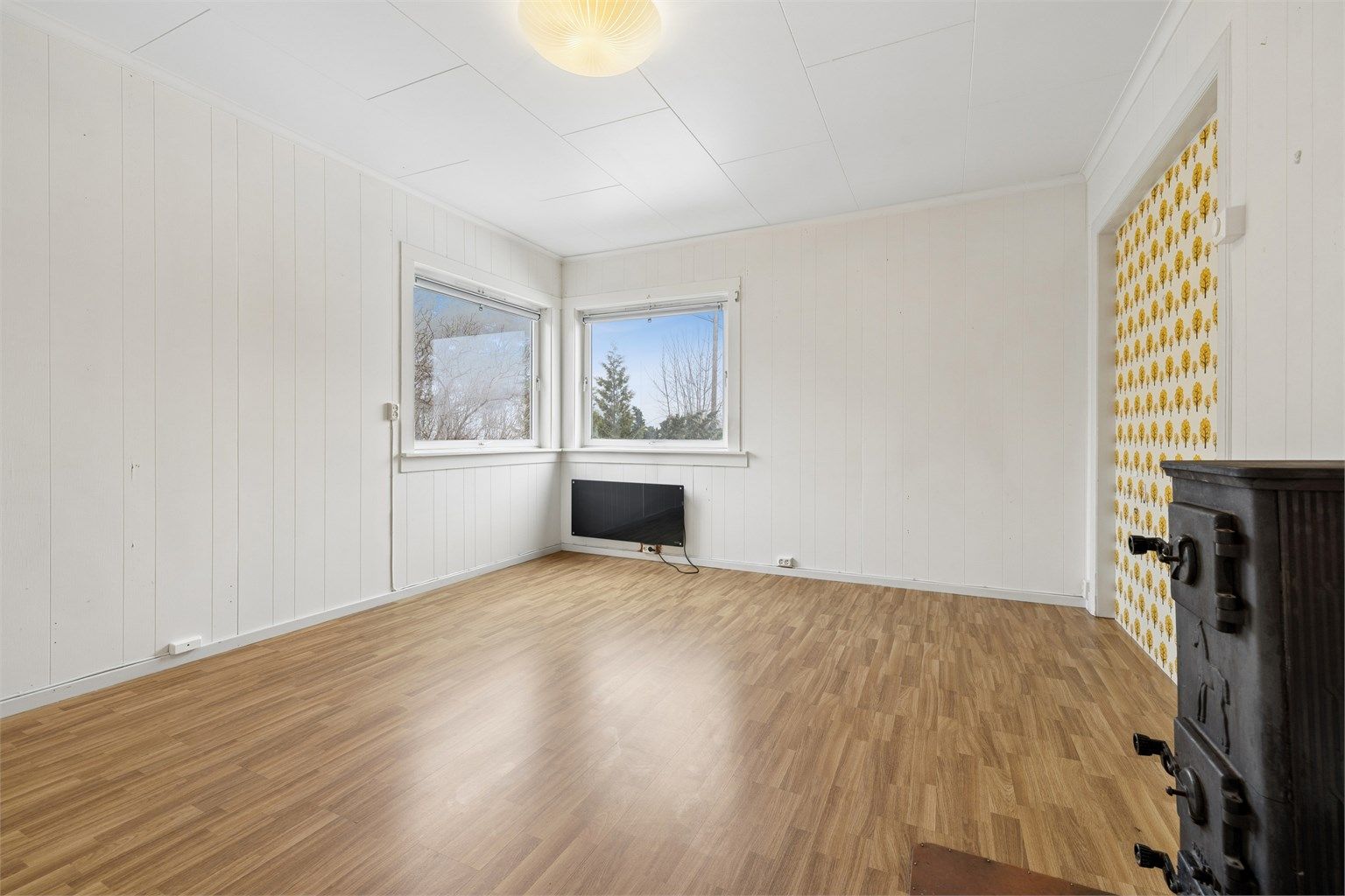 Stuen i første etasje har laminat på gulvet og en vedovn i støpejern for ekstra varme.